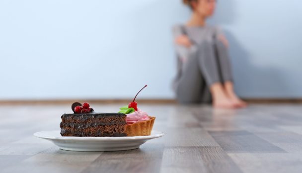 Desperate,Woman,Sitting,On,The,Floor,On,Grey,Wall,Background.