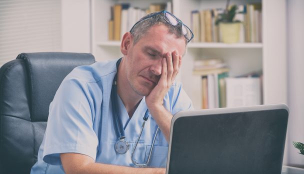 Overworked,Doctor,Sitting,In,His,Office